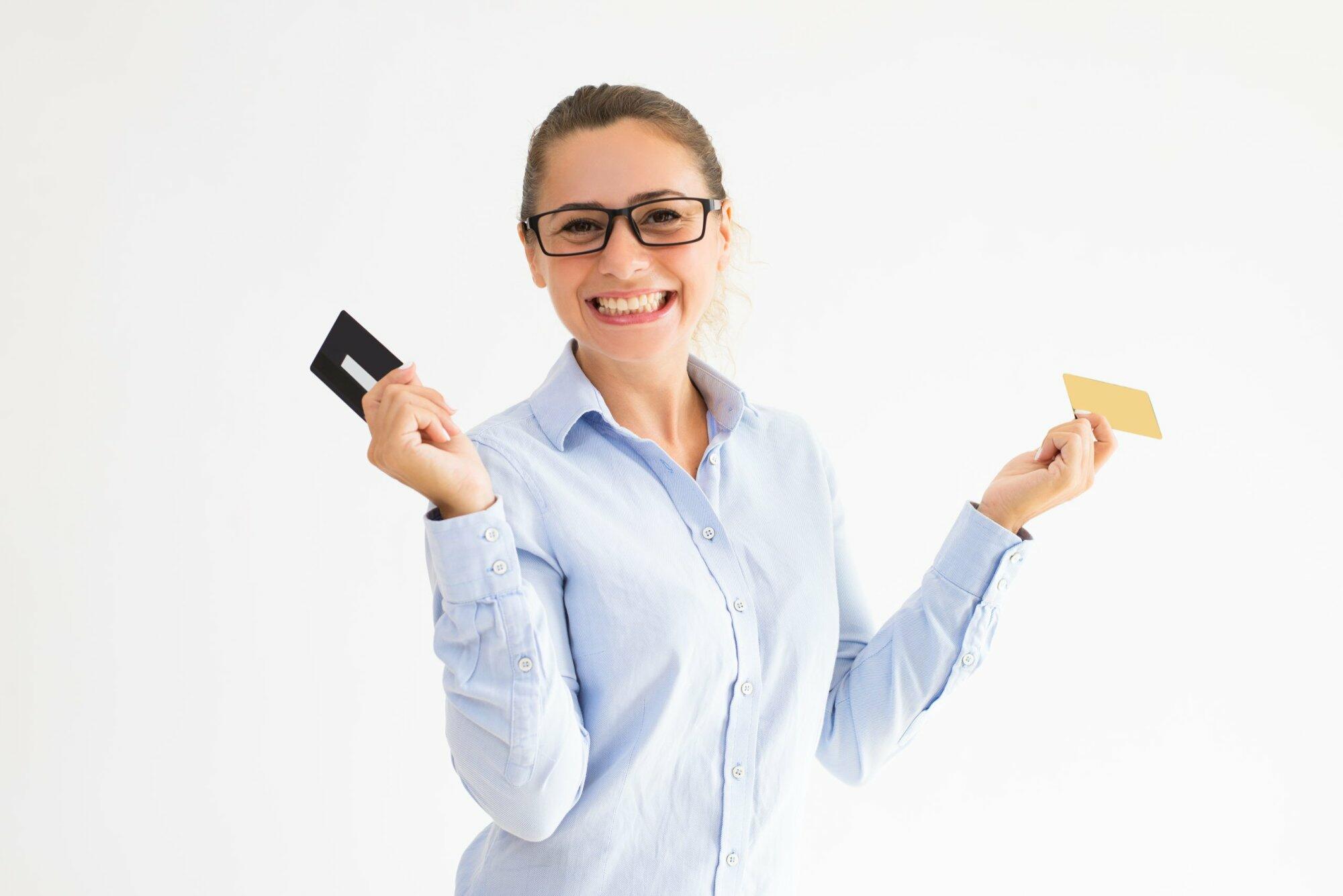 Positive female shopper holding several loyalty cards Positive female shopper holding several loyalty cards. Cheerful Caucasian girl in formal wear holding two plastic cards, one per hand. Loyalty program concept